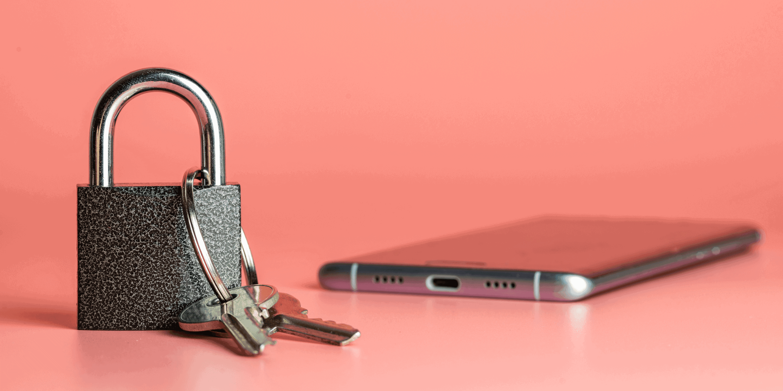 A silver padlock with two keys