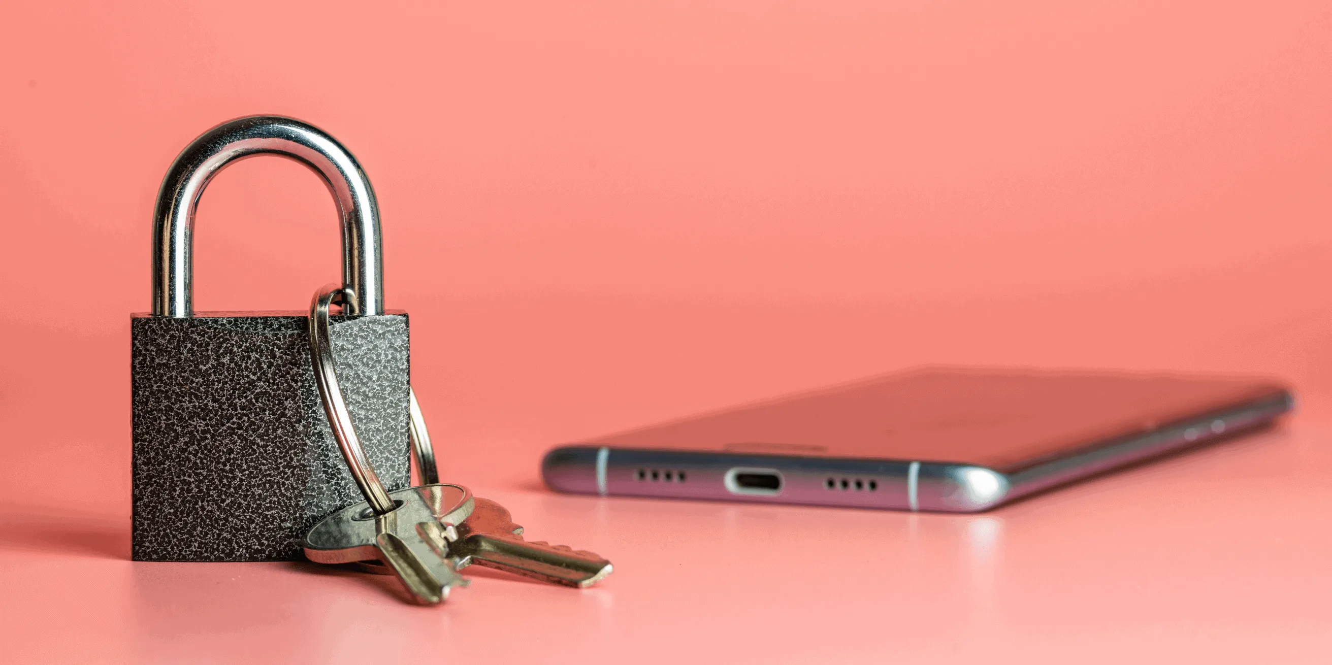 A silver padlock with two keys