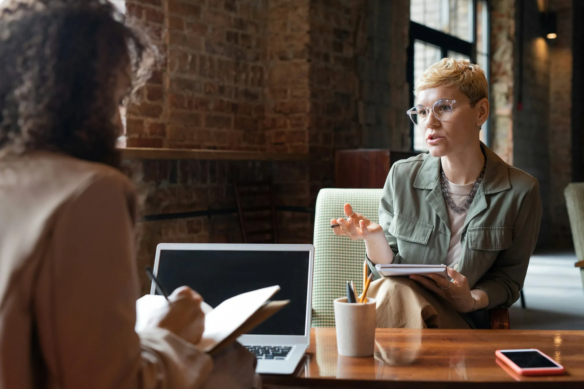 Two individuals are in a business meeting at a café.