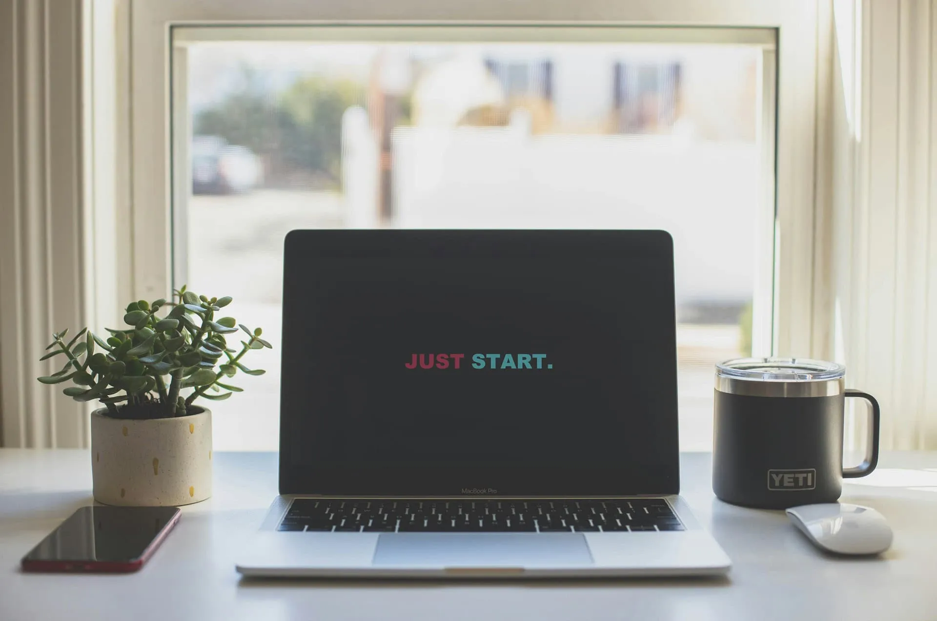 A laptop on a desk displays the words 