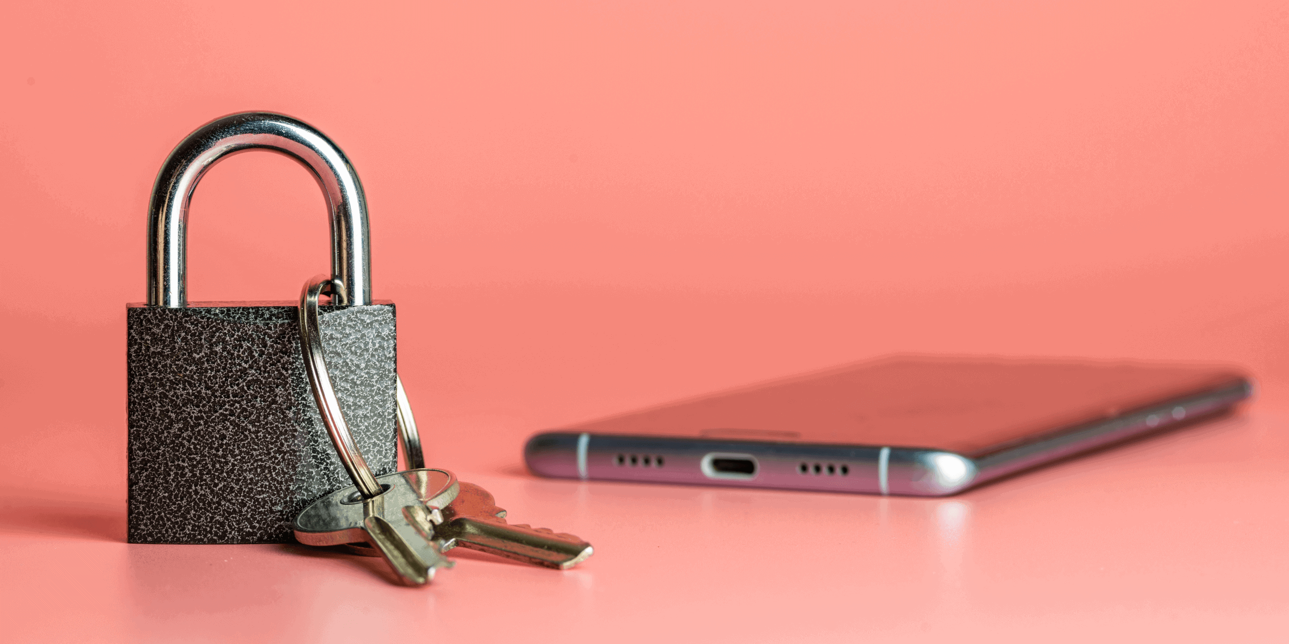 A silver padlock with two keys