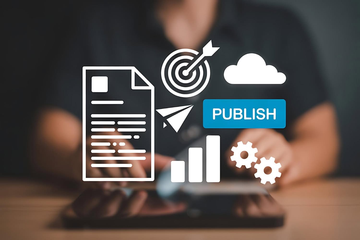 A person uses a tablet, with digital icons overlaid showing a document, target, cloud, "publish" button, and gears—illustrating content creation and publishing strategies used by content marketing agencies for New Year planning. - Market Design Team: Define. Structure. Expand.