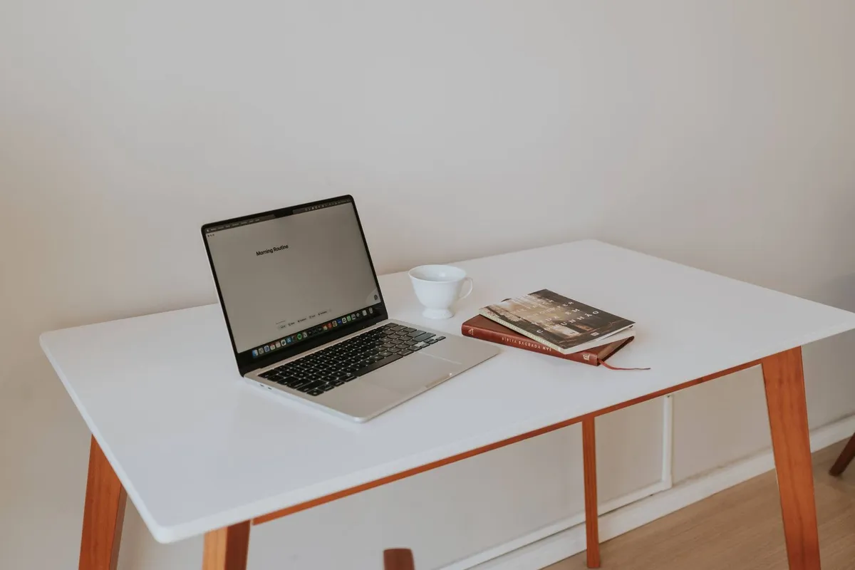 A clean workspace with a laptop, coffee cup, and books, symbolizing focus on SEO for small businesses.